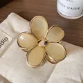 Elegant cream gradient flower hair claw clip with gold trim on beige linen background - Khaki Flower Claw