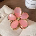 Pink gradient flower hair claw with golden edges on a neutral linen fabric background - Transparent Pink Flower Claw