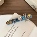 Blue denim hair clip with colorful rhinestones and a silver metal bow detail - Light Denim Rhinestone Hair Clip