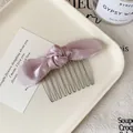 Pink satin bow hair comb with ten golden metal teeth on a ceramic tray display - Dusty Pink Bow Hair Comb