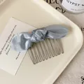 Light blue satin bow hair comb with silver metal teeth on a ceramic tray - Blue Bow Hair Comb