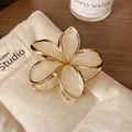Eleganter cremefarbener Frangipani Haarklammer mit goldenen Metallkanten auf Leinwand - Cremeweiß