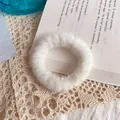 Coletero de piel sintética blanca suave sobre fondo de encaje vintage y un libro - Blanco