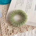 Coletero verde aguacate de piel de conejo sintética sobre una página de libro - Verde Menta