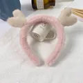 Pink plush reindeer antler headband with cream heart decorations on a textured cloth - Pink Headband Cream Antlers