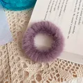 Plush faux fur scrunchie in Morandi purple on elegant book and lace background - Purple