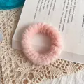Soft pink plush faux fur hair scrunchie placed on an open book for a cozy aesthetic - Light Pink