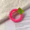 Fluorescent pink spiral telephone wire hair tie with a green smiley face cloth label - Rose Red