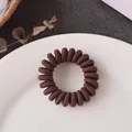 Dark brown spiral telephone wire hair tie in a minimalist aesthetic setting - Chocolate