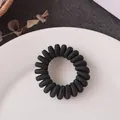 Élastique à cheveux spirale noir avec texture tissée présenté dans un plateau blanc - Noir