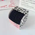 Set of black elastic hair ties in a pink cow-patterned gift box on a white background - Black Style A