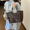 Sac fourre-tout marron matelassé avec chaîne dorée porté par un mannequin pour le bureau - Café