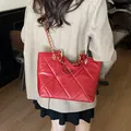 Sac bandoulière rouge matelassé avec chaîne dorée porté sur un tailleur beige - Rouge