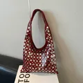 Chic burgundy patent leather underarm bag with silver rivets and sleek curved design - Red