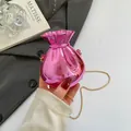 Metallic bright pink candy bag with gold chain strap shown in a fashion setting - Pink