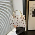 Witte kussentas met kersenprint, dubbele handvatten en afneembare schouderriem - Wit