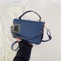 Petit sac à main bleu marine avec boucle dorée et bandoulière en chaîne porté à la main - Bleu