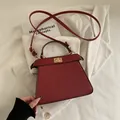 Bolso de mano trapecio minimalista en cuero rojo oscuro con cierre dorado y bandolera - Rojo