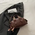 Vintage dark brown Boston bag with golden rivets on a black blazer, retro crossbody style - Brown