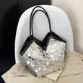 Sac fourre-tout à paillettes argentées et lanières noires sur un trench beige - Argent