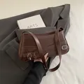 Dunkelbraune Leder-Schultertasche mit dekorativen Gürteln und Silberschnallen für Damen - Braun