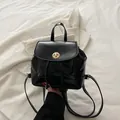 Mini sac à dos noir avec fermoir doré rotatif et bretelles réglables dans un décor chic - Noir
