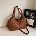 Brown leather dumpling tote bag with dual metal zippers and adjustable shoulder strap - Brown