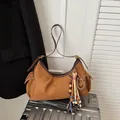 Sac à épaule en daim marron avec glands bohèmes et perles en bois sur une valise - Marron
