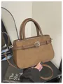 Detail of brown bucket bag showing suede and synthetic leather patchwork with strap accent - Brown