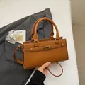Détail du sac en cuir caramel avec fermoir tournant en métal doré et brides latérales - Marron
