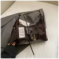 Dettaglio della borsa hobo caffè scuro con finitura lucida e chiusura a zip in metallo oro - Marrone