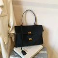 Minimalist black matte leather underarm tote bag with dual gold twist locks and long strap - Black