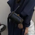 Sac cylindre noir chic avec ferrures dorées et un pompon marron en fausse fourrure - Noir