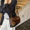 Brown retro cylindrical pillow bag with gold lock and plush charm for daily wear - Brown
