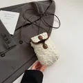 Close-up of fuzzy faux shearling bag with contrast leather trim and horn buckle detail - White