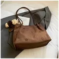 Detail of suede shoulder bag with floral cut-outs and cute plush bear charm - Coffee With Pendant