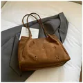 Macro view of brown suede tote bag featuring laser-cut floral patterns and slender straps - Brown No Pendant