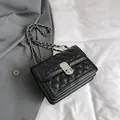 Elegant black quilted crossbody bag with silver chain strap and metal lock closure - Black