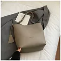 Détail du cuir grainé et du pendentif géométrique sur le sac seau de couleur kaki foncé - Gris éléphant