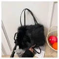 Dettaglio ravvicinato di una borsa in finta pelliccia nera con manici in pelle - Nero