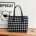 Grande borsa tote in tela a scacchi bianchi e neri con manici in pelle e borchie d'oro - Nero