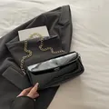 Borsa a spalla minimalista in pelle verniciata nera con catena d'oro e fibbia - Nero
