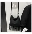 Detail view of the black crossbody bag showing the long fringe tassel design and matte texture - Black
