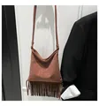 Detail of brown suede crossbody bag featuring long bohemian tassels and soft texture - Brown