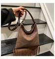 Detail of dark brown suede hobo bag featuring long tassels and minimalist shoulder strap - Coffee