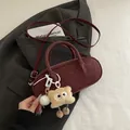 Elegant burgundy baguette shoulder bag features a cute fluffy plush monster charm accessory - Red with Pendant