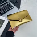 Elegant gold metallic envelope clutch bag with brushed texture and oval buckle - Gold