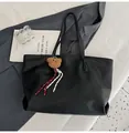 Bolso tote vintage negro de cuero con un colgante de oso de peluche marrón suave - Negro