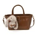Détail du sac à main en cuir marron avec boucle décorative et breloque lapin en peluche - Sans pendentif / Marron