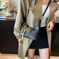 Chic black woven texture hobo bag with colorful beads detail in a modern cafe setting - With Pendant / Black
